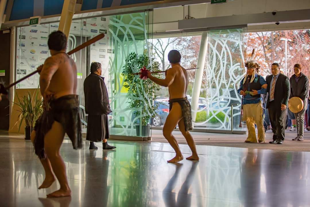 Kapa haka performers welcoming manuhiri with taiaha at a WISPC gathering